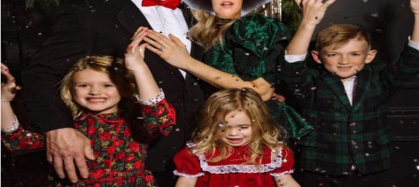 The Atkinson family 2021 Christmas photo with the family dog pooing on the son’s shoes